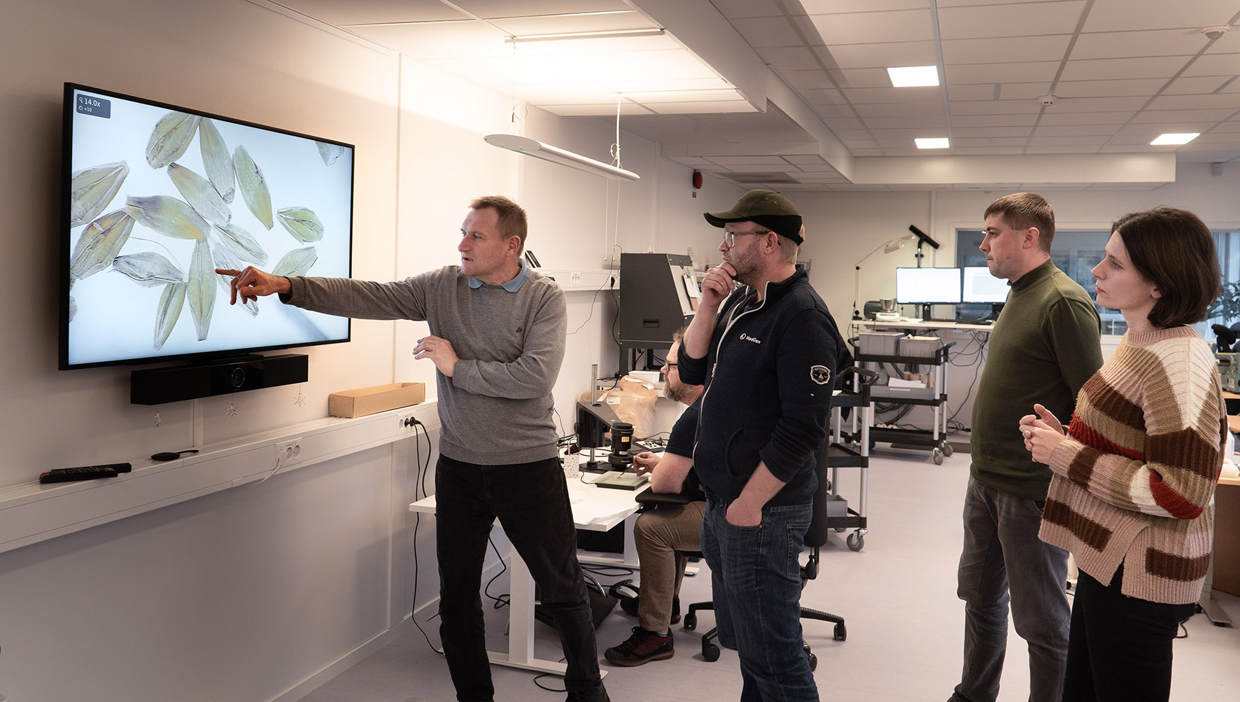 A group of people looking a screen showing seeds.