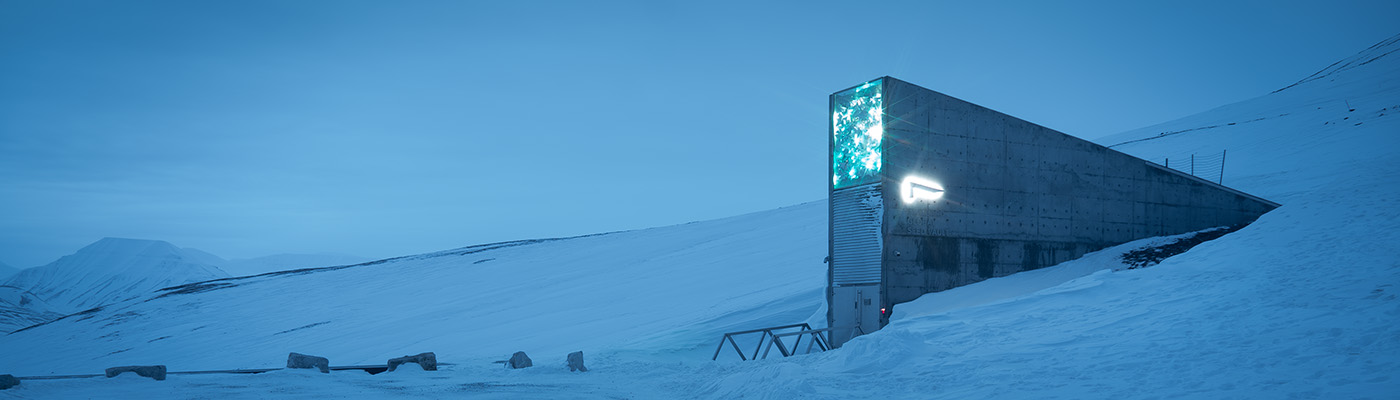 A wedge-shaped building surrounded by a snowy and mountainous landscape.